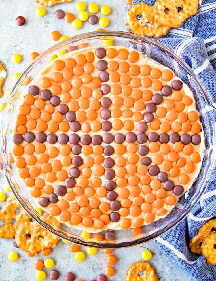 Overhead image of peanut butter dip in a clear glass pie plate with candies on top in the shape of a basket ball