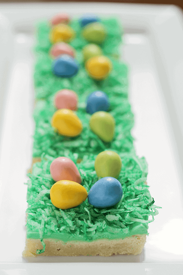 Easter Egg Hunt Sugar Cookie Bars ~ Soft, Chewy Sugar Cookie Bars topped with Green Coconut “Grass” and Candy Easter Eggs!