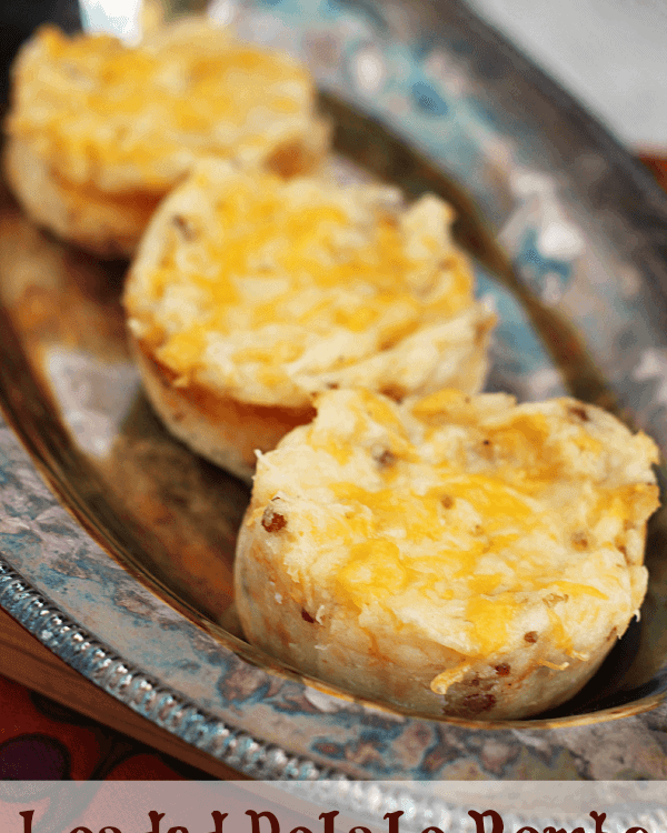 Three loaded potato bombs in a row on a silver serving tray