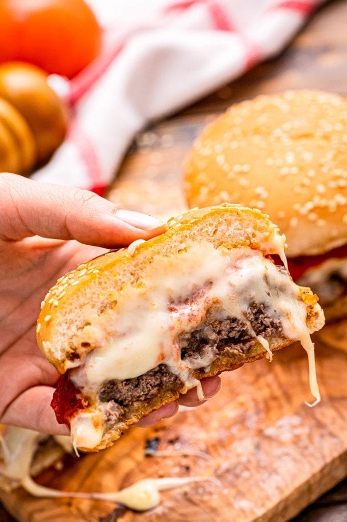 Burger Cut in half on bun with melted cheese oozing out of it