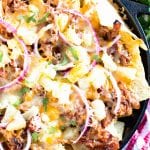 Cast iron skillet of pulled pork nachos