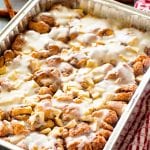 Foil pan of cinnamon apple monkey bread with icing on it