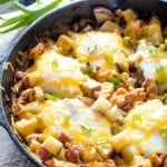 Cast iron skillet of potatoes, bacon, eggs, and cheese