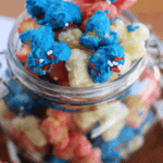 Glass jar of patriotic puff corn with red white and blue sprinkles