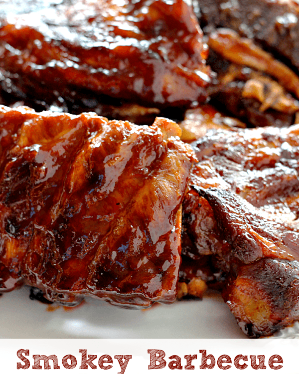 Several racks of smokey barbecue ribs on a white plate