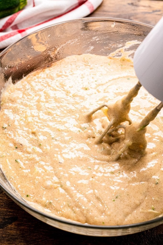 Banana Zucchini Bread batter that's mixed in a glass bowl with hand mixer still in batter.