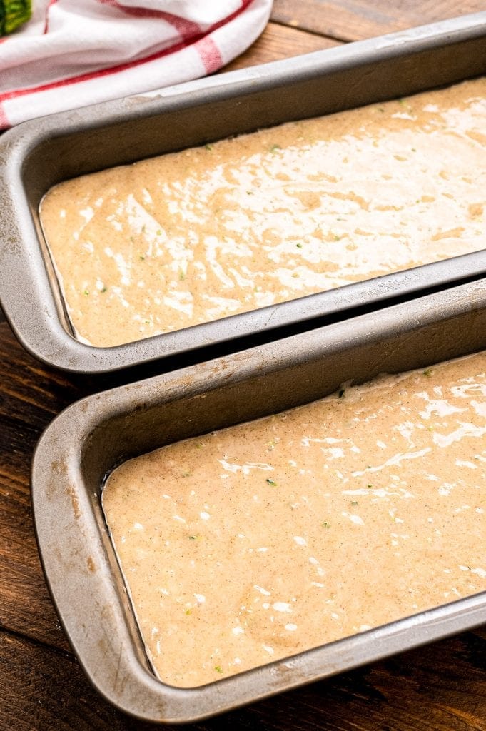 Two loaf pans with Banana Zucchini Bread batter in it.