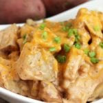 Crock pot cheesy ranch potatoes in a white bowl topped with chives