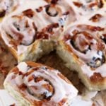 Candied bacon cinnamon rolls on a table with one rolled pulled off