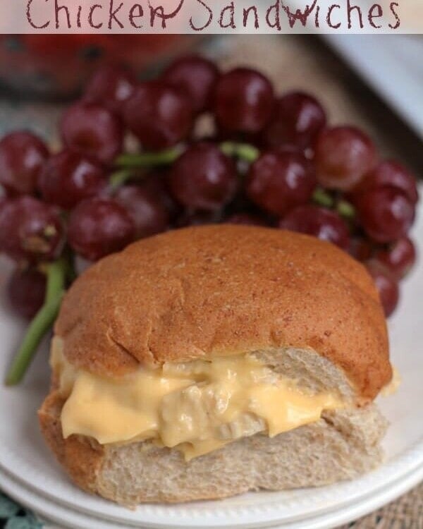 Easy cheesy chicken sandwich on a white plate with grapes