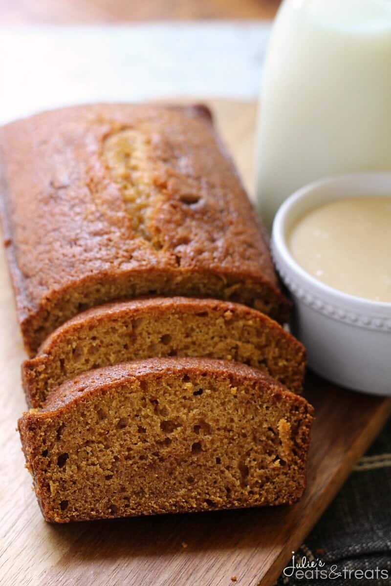 A Pumpkin Loaf with a jar of Caramel Glaze on a wooden cutting board.