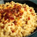 Bacon chipotle mac and cheese with bacon bits on top in a black bowl