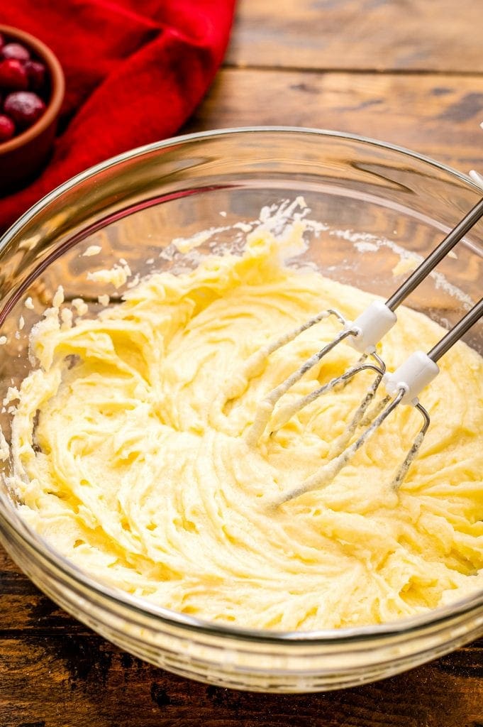 Hand beater in a glass bowl of muffin batter.