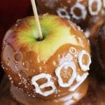 Two salted caramel apples with boo written in white on the caramel