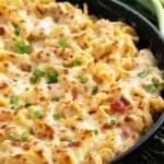 A cast iron skillet pan of roasted red pepper chicken alfredo bake