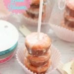 Three strawberry lemon blossom mini cupcakes on a stick sitting on a cupcake liner