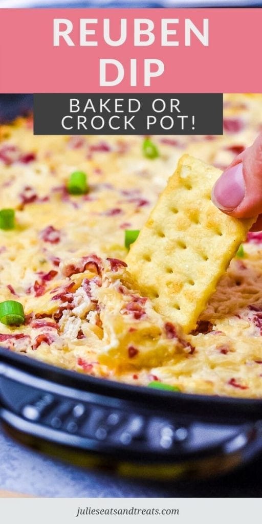 Hand dipping a cracker into Reuben Dip