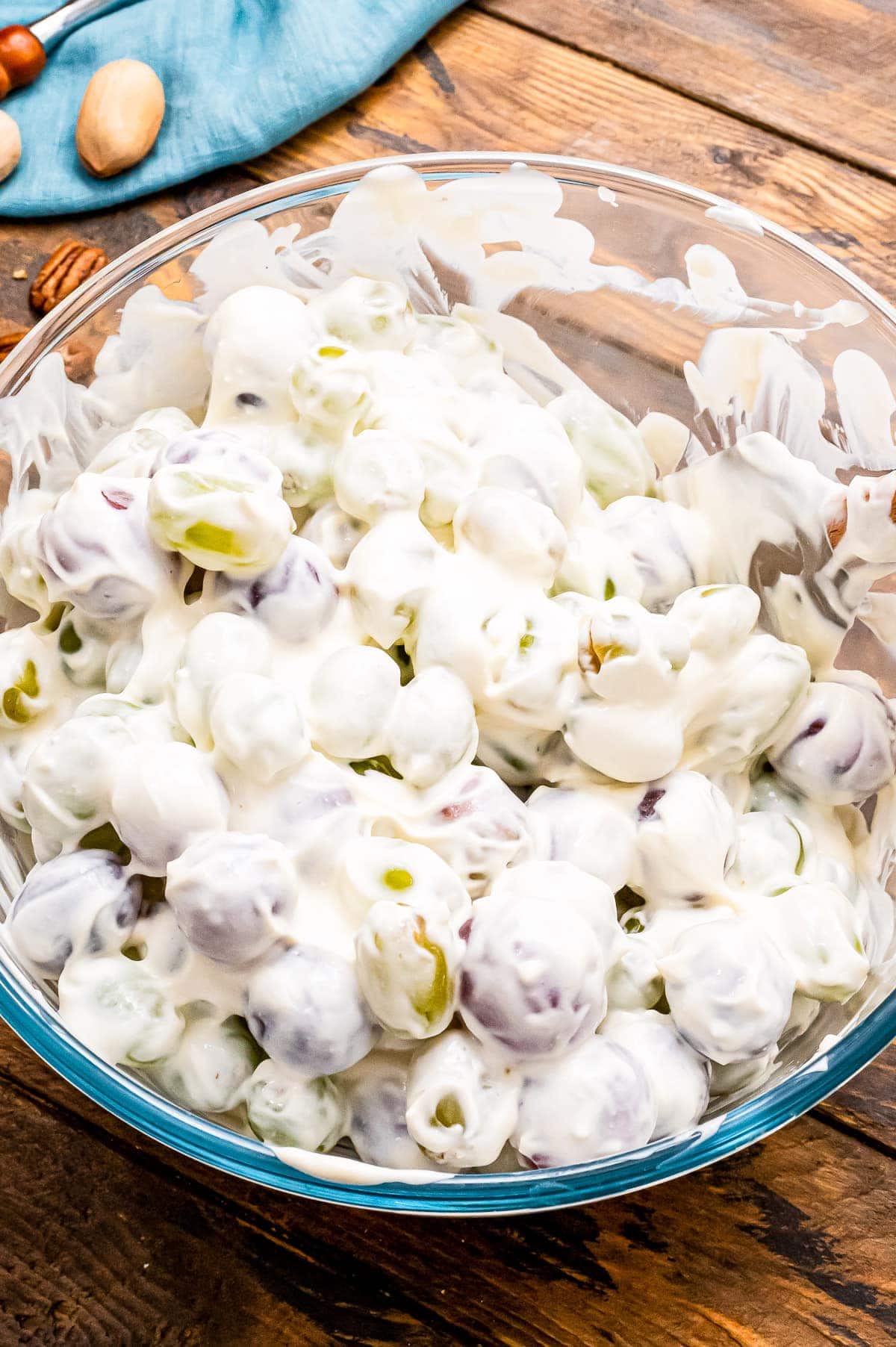 Glass bowl with grape salad in it and blue napkin in background