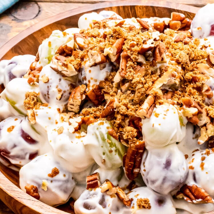 Close up of Grap Salad in wood bowl with brown sugar and chopped pecans on top