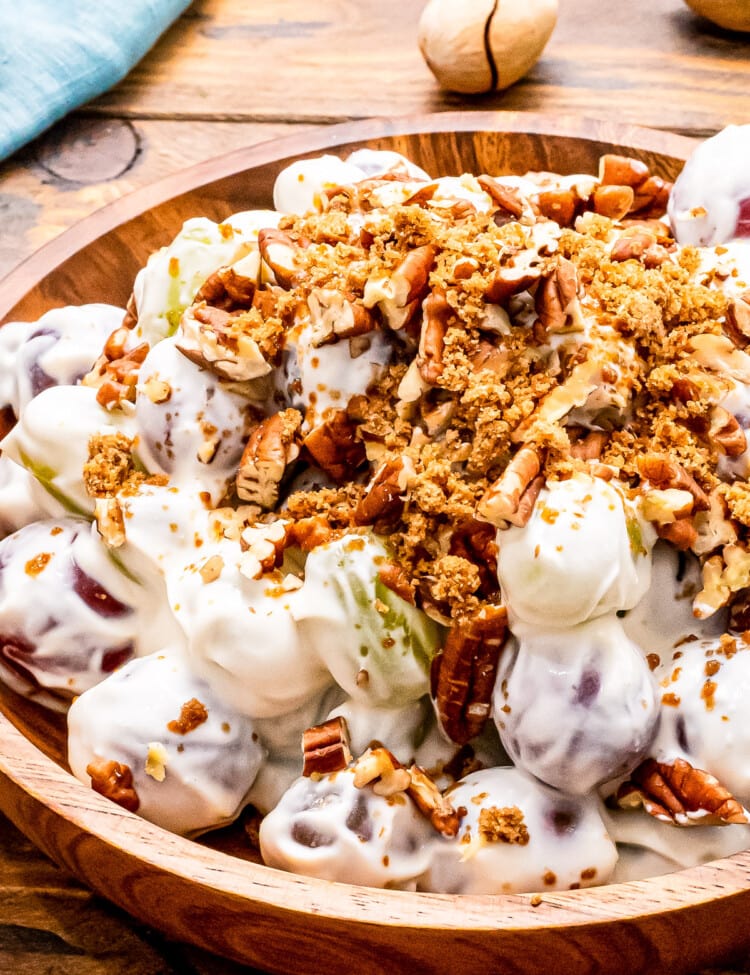 Close up of Grap Salad in wood bowl with brown sugar and chopped pecans on top