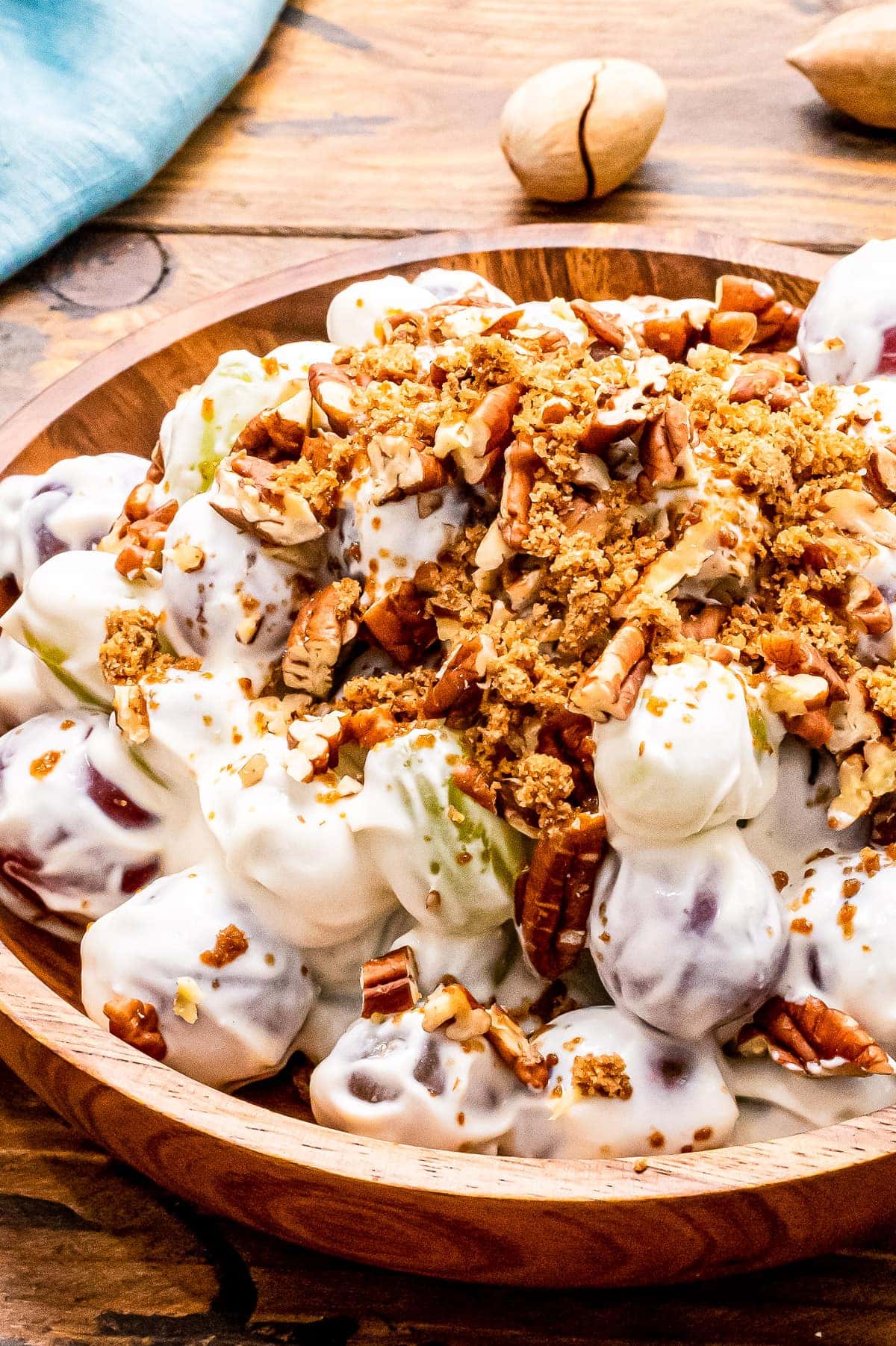 Close up of Grap Salad in wood bowl with brown sugar and chopped pecans on top