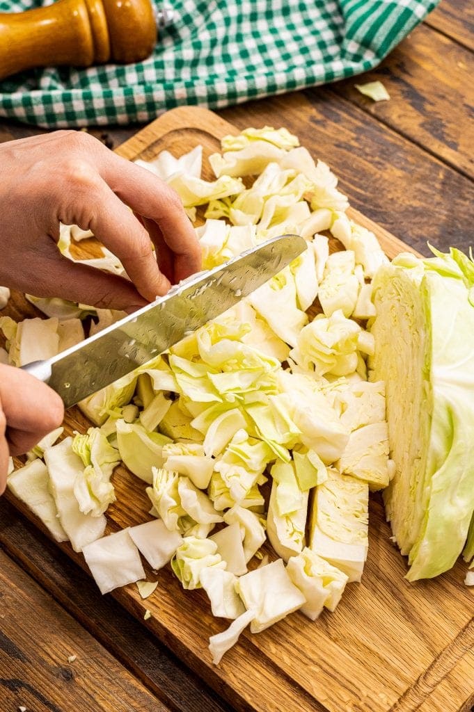 Chef knife diced a head of cabbage on wood cutting board