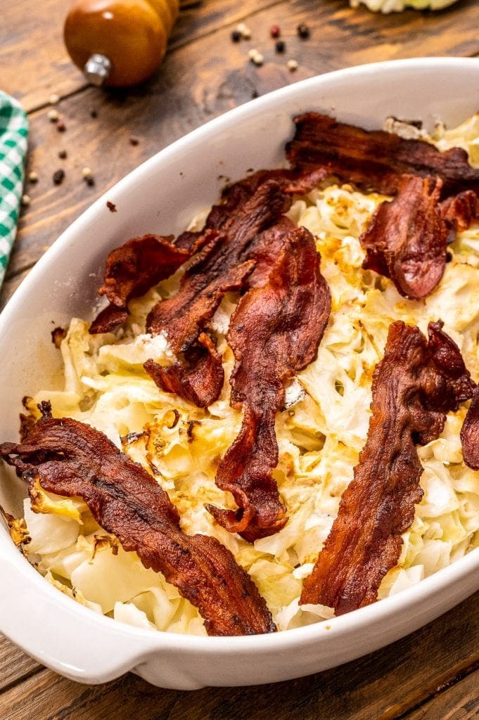 Cooked cabbage casserole before chopped cooked bacon on top.