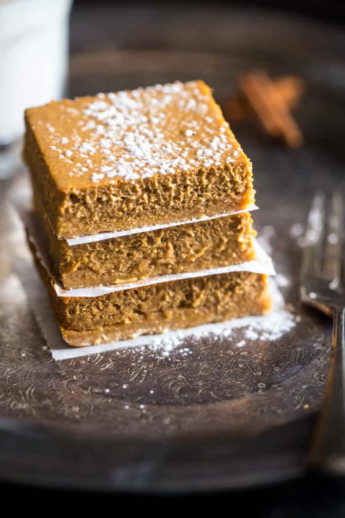 Skinny Gluten Free Pumpkin Cheesecake bars - These easy pumpkin cheesecake bars have a spicy-sweet gluten free crust and are so creamy! You'd never know they're only 150 calories! | Julieseatsandtreats.com |