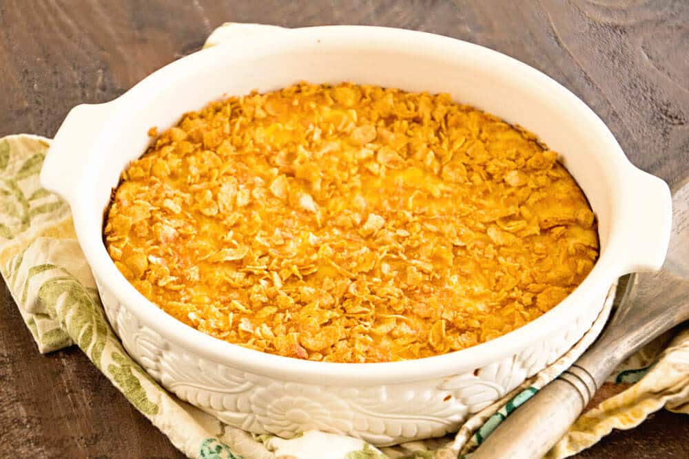 Step by step directions how to make corn pudding recipe ~ served in a white casserole dish topped with a crunchy corn flake topping!