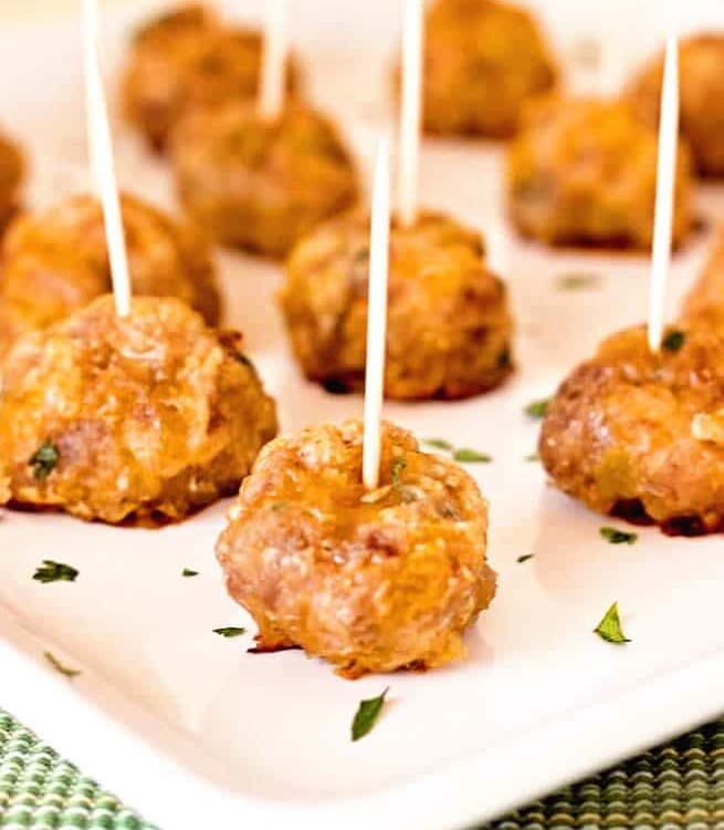 Mexican sausage balls with toothpicks in each one on a white plate