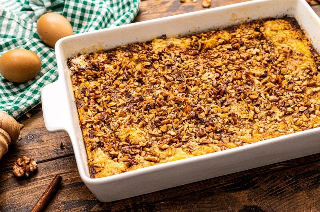 Pumpkin Dump Cake in white rectangle baking dish with green and white checkered napkin behind it.