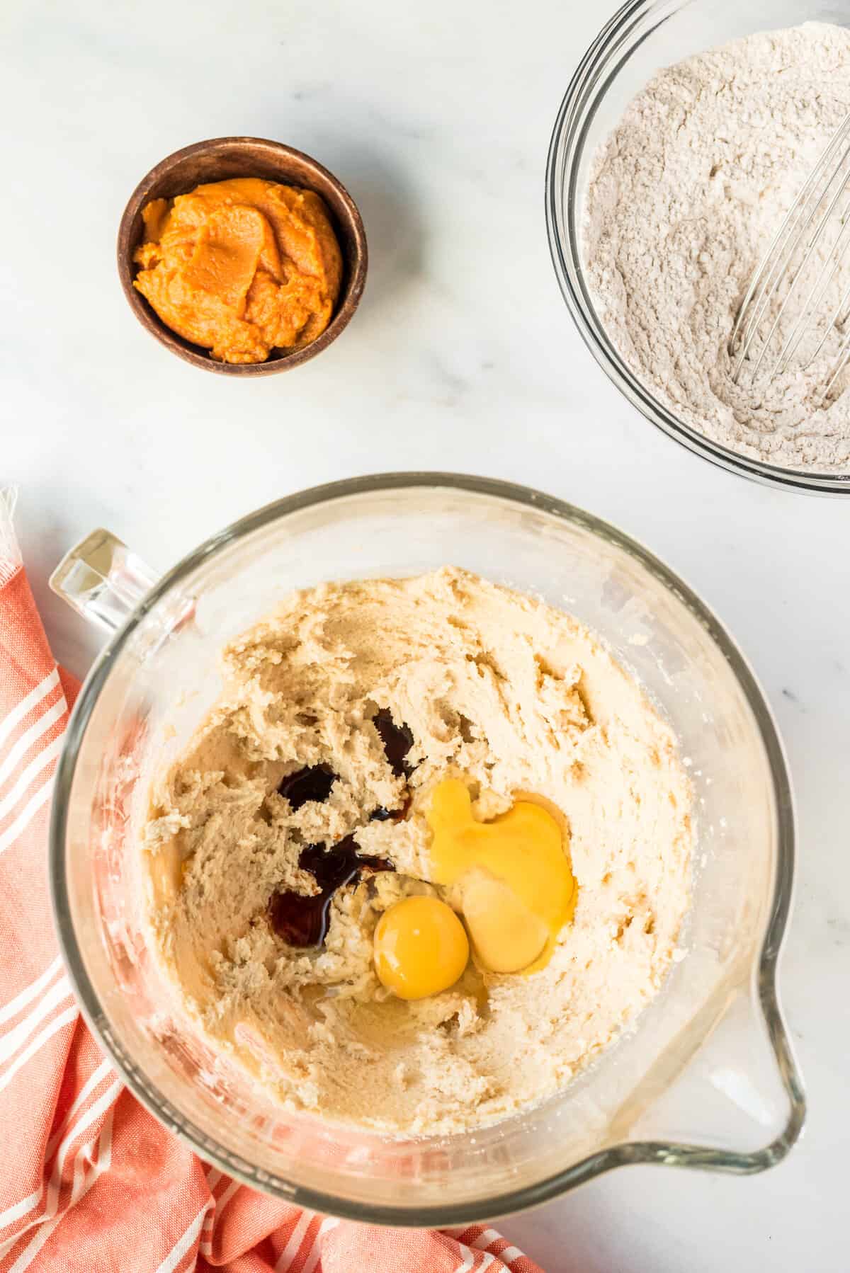 Creamed ingredients plus eggs and vanilla for pumpkin cookies in bowl