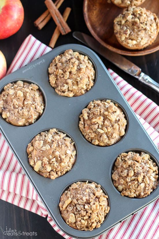 Overhead image of a tin of 6 muffins with streusel topping on red striped napkin.