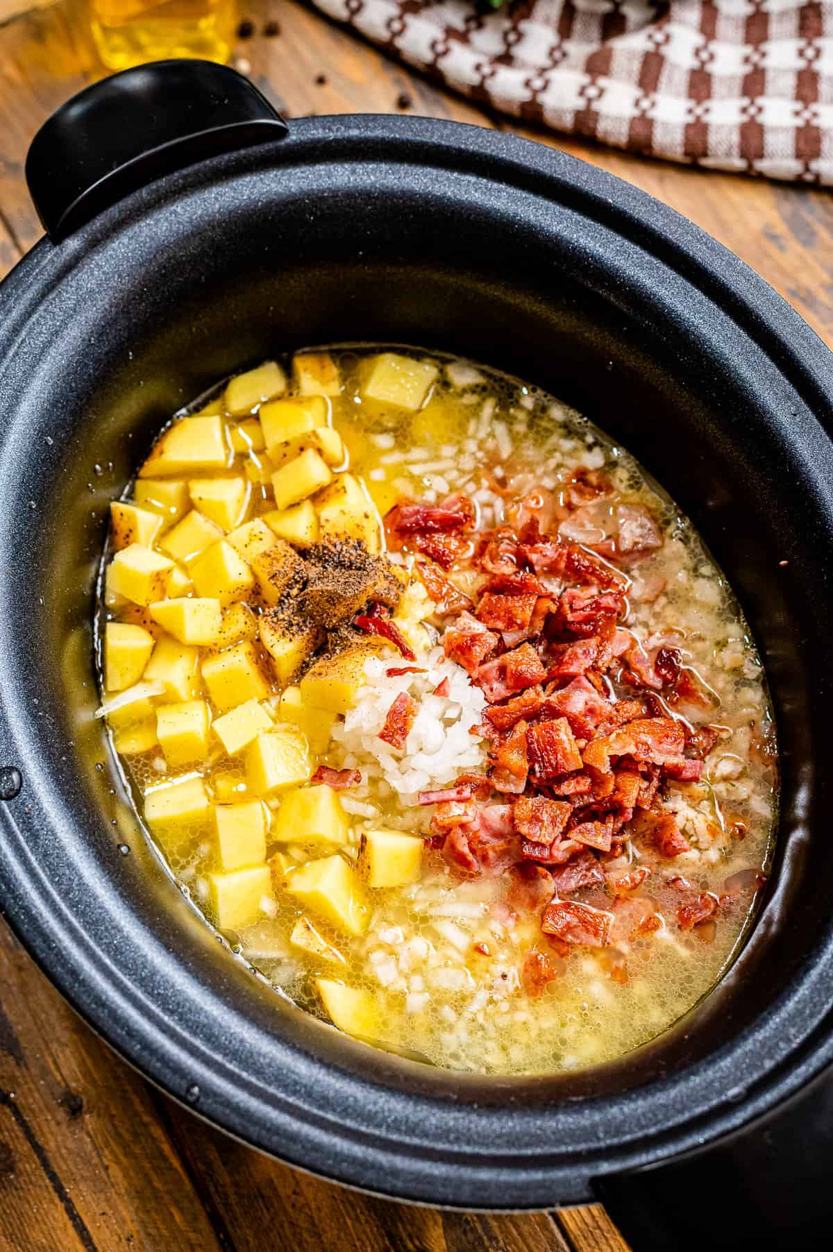 Ingredients in black crock pot to make zuppa toscana