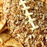 A football cheeseball surrounded by pita chips