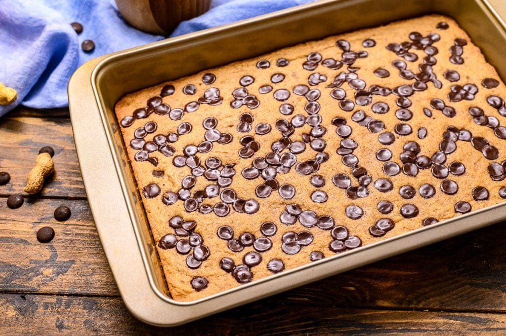 Pan of baked bars on wooden background with blue napkin in background