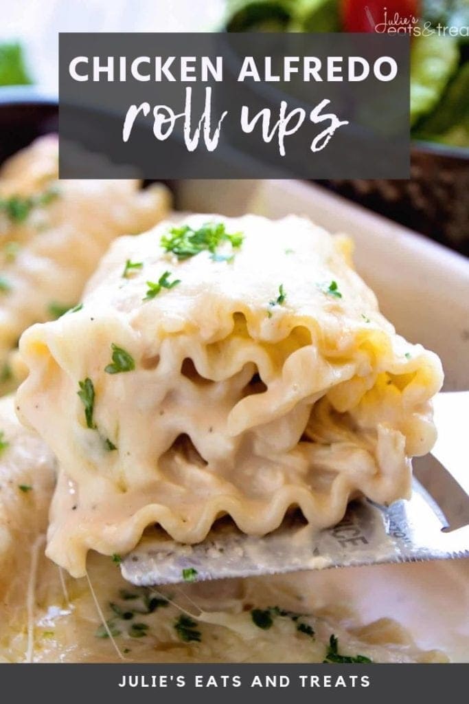 Chicken alfredo roll up on a spatula being lifted out of a white casserole dish