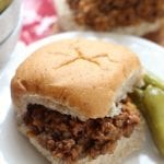 Auntie's barbecue meet on a bun with pickles on a white plate