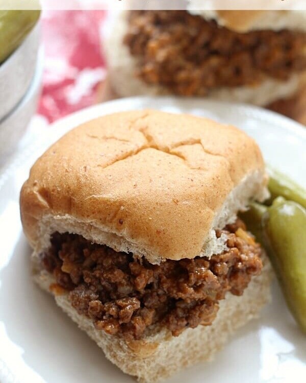 Auntie's barbecue meet on a bun with pickles on a white plate