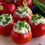 Four chicken bacon ranch salad stuffed tomatoes on a wood stump