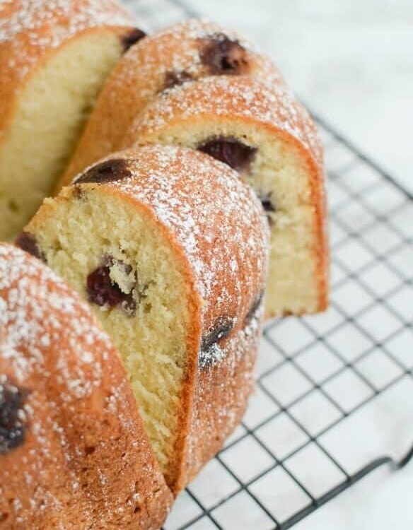 Slices of a bundt shaped blueberry sour cream pound cake on a cooling rack