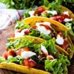 Three easy stuffed tacos on a wood cutting board