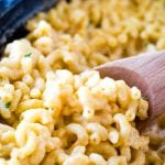 Smoked mac and cheese being scooped with a wood spoon