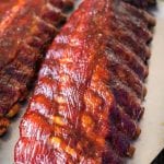 Two racks of smoked pork ribs on a baking sheet