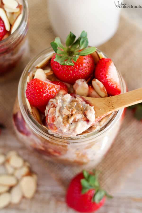 Spoon with overnight oats sitting on top of a small glass jar