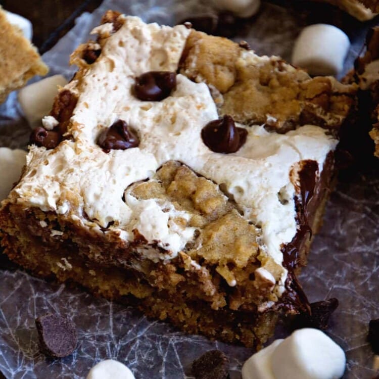 Close up image of a s'mores bar on wax paper with chocolate chips, mini marshmallows, and graham crackers