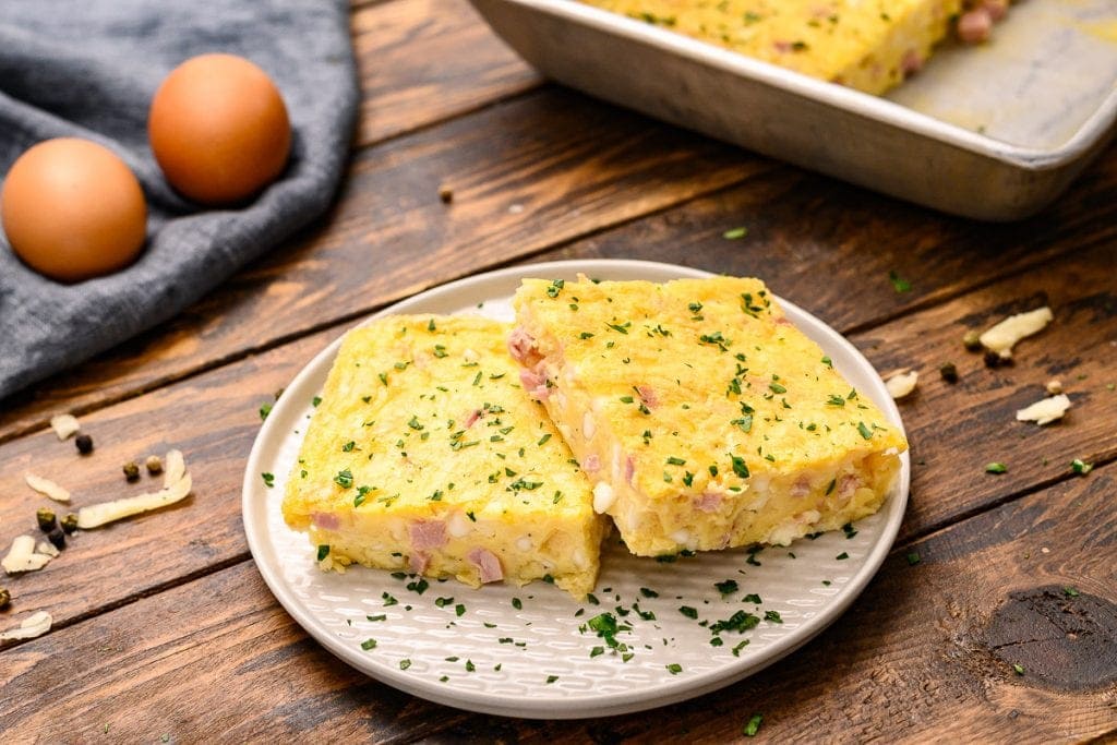 White plate with two pieces of baked omelet on it