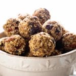 White bowl of oatmeal raisin energy balls