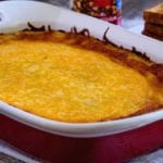 Overnight corned beef hash breakfast casserole in a white and red baking dish