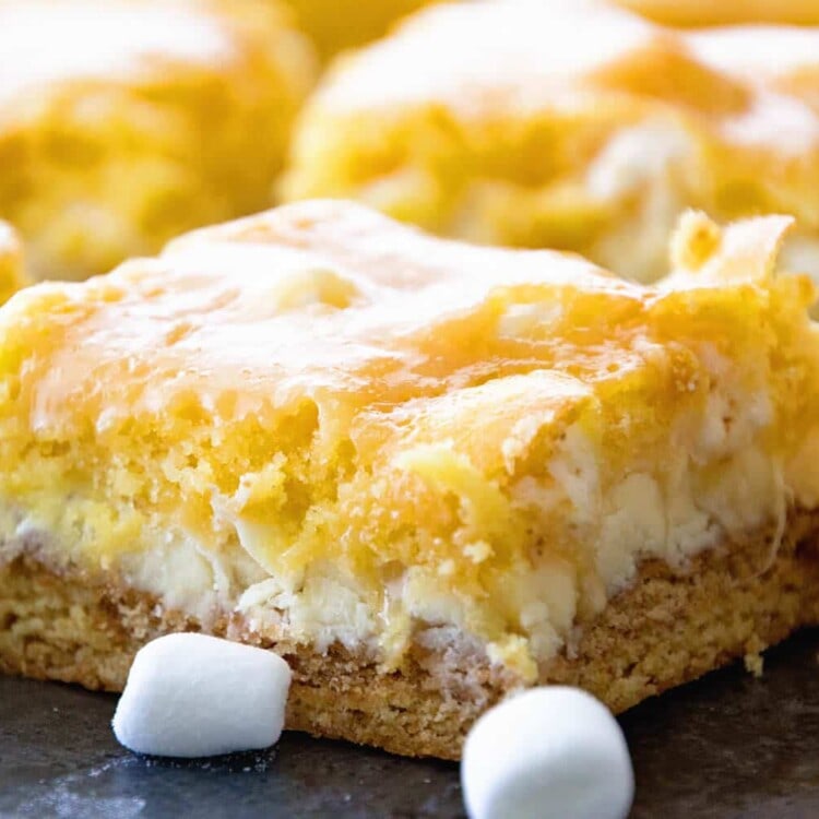 Side view of white chocolate smores bars on a counter with min marshmallows